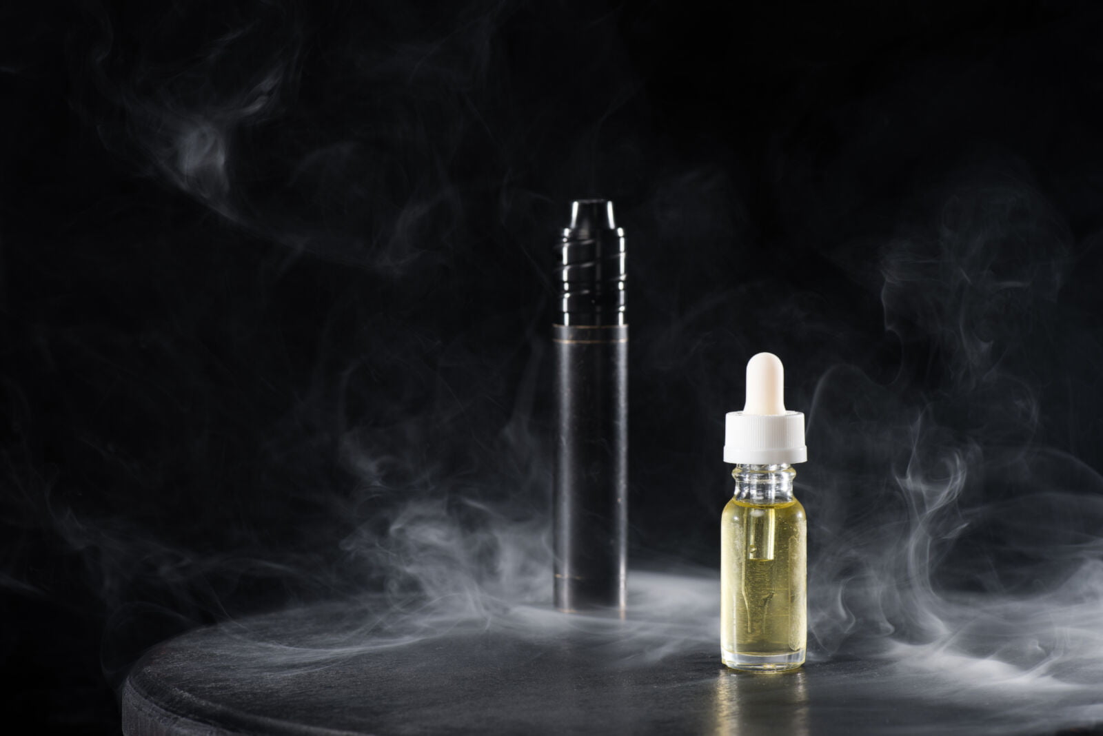 electronic cigarette and liquid with clouds of smoke on dark background